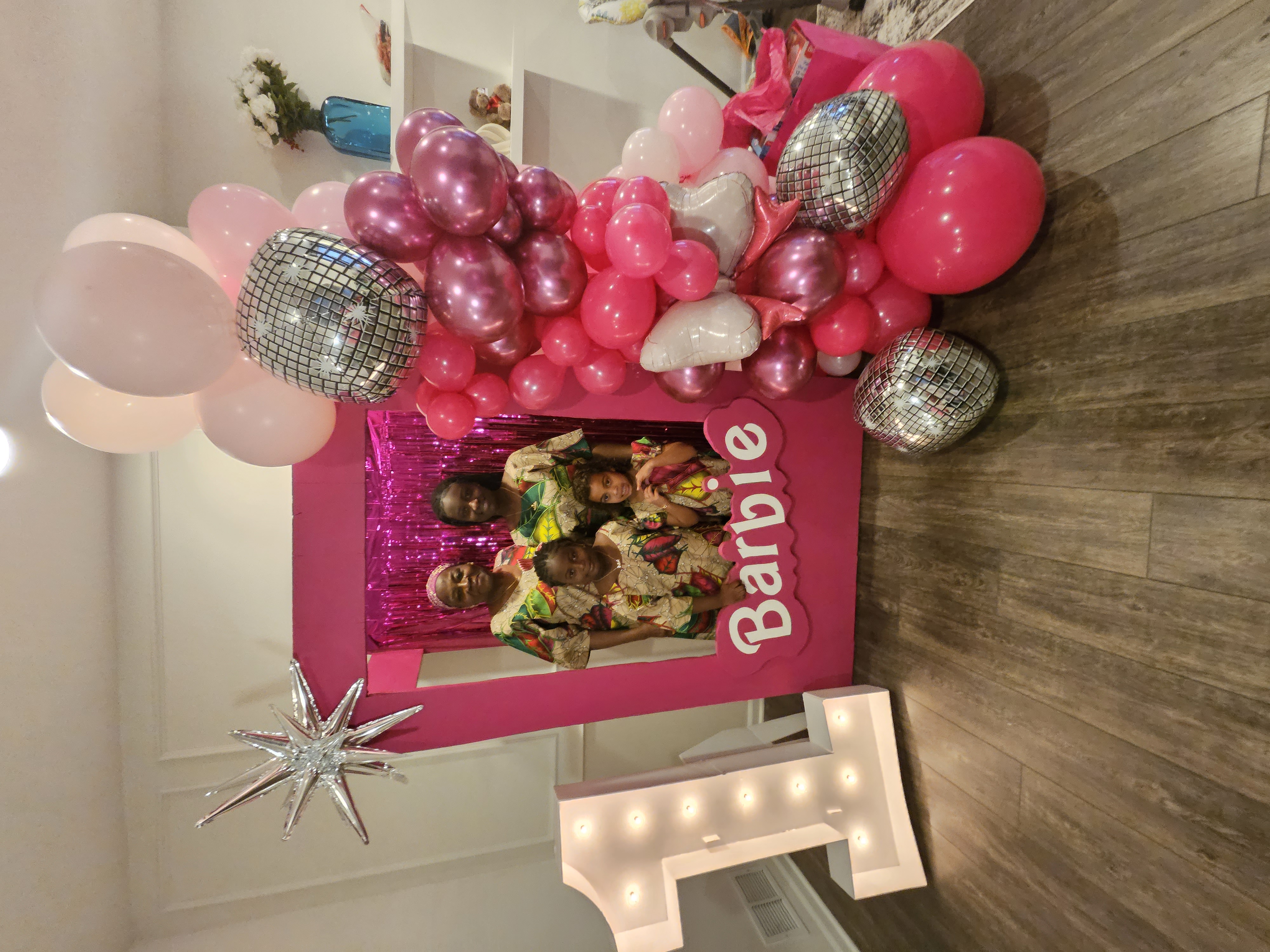 Barbie themed birthday party with pink balloon garland and photo frame backdrop