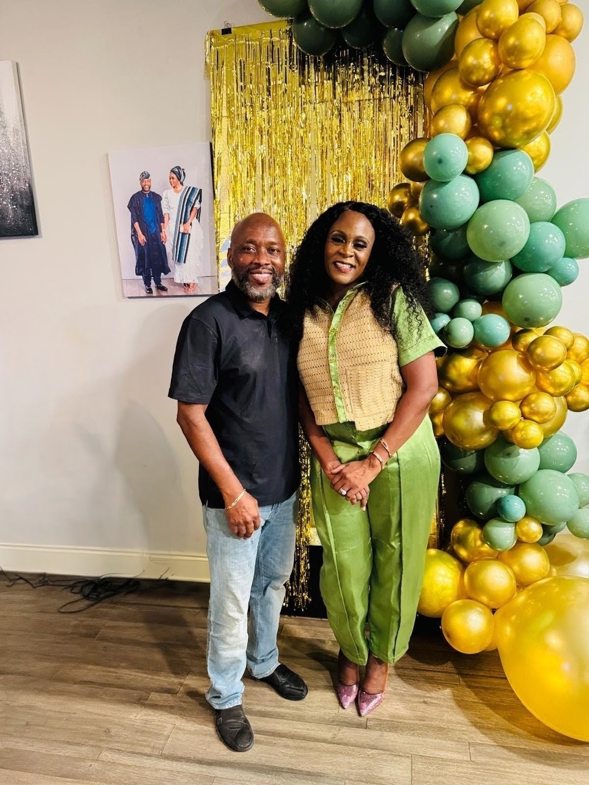 Sage green and gold balloon arrangement with tinsel backdrop